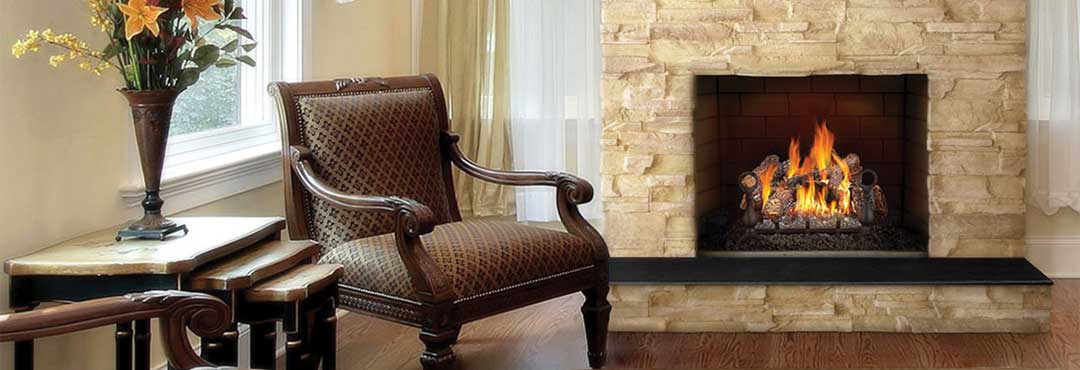 Napoleon Vented Gas Log Set with rock surround and granite hearth. Victorian chair to the left.