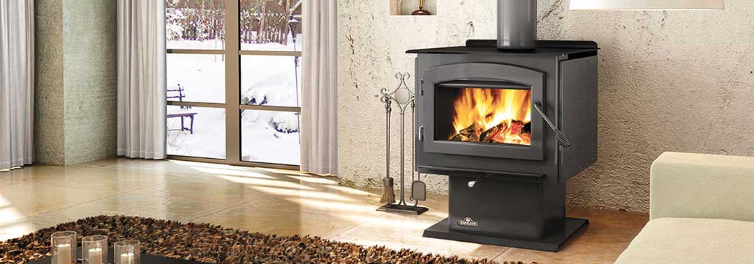 Napoleon Wood Stove Independence1450 beautiful in black with fire and tools to the left.