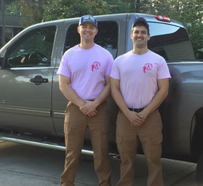 Traditions Chimney Sweeps original photo of techs wearing Breast Cancer Awareness. Techs standing in front of truck wearing t-shirts for Breast Cancer Awareness.